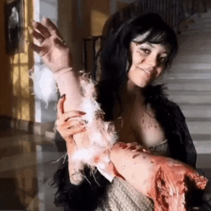 a woman in a black fur coat is holding a bloody hand .