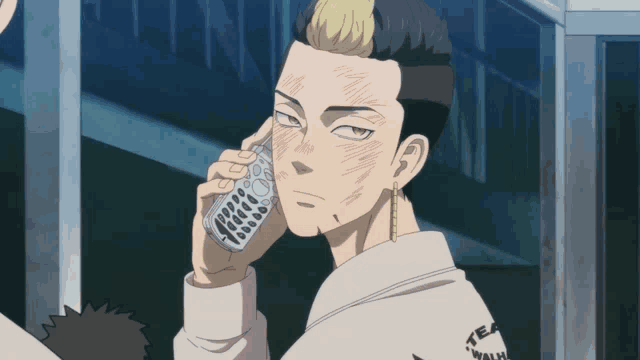 a man is talking on a cell phone and his shirt says team walk on it