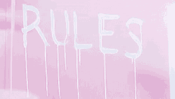 the word rules is written on a pink wall with white paint dripping down it .