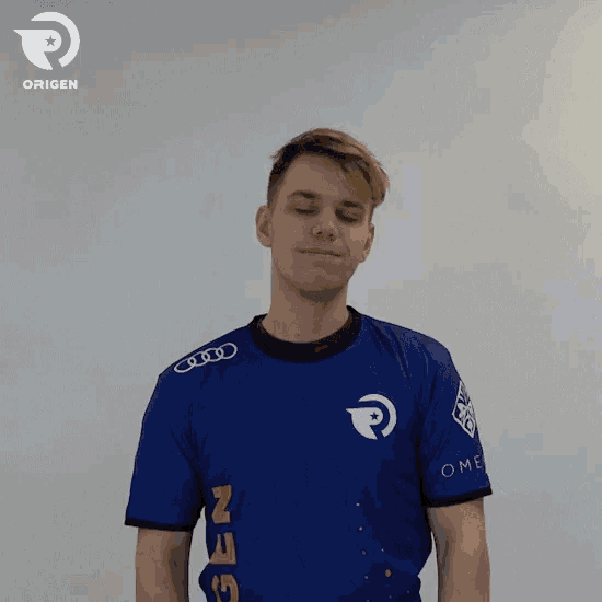 a man wearing a blue shirt that says origen
