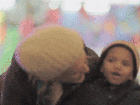 a blurry picture of a woman kissing a child