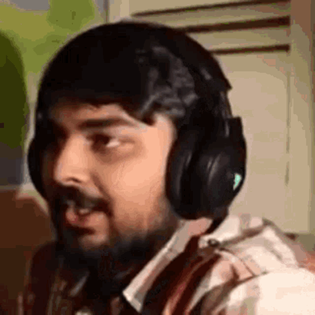 a man wearing headphones is making a funny face .