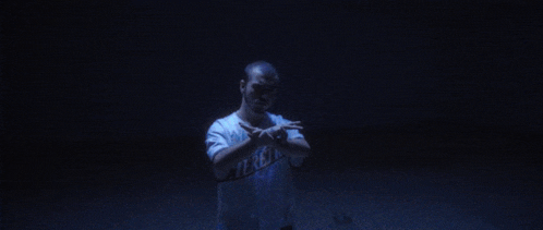 a man wearing a la shirt is making a peace sign with his hands