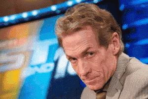 a man in a suit and tie is making a funny face in front of a tv screen