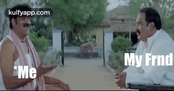 two men are sitting next to each other and talking to each other in front of a house .