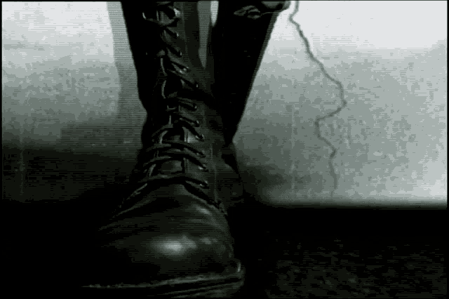 a black and white photo of a person wearing a black boot