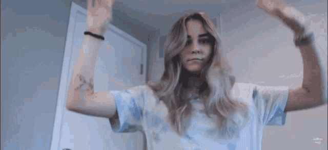 a woman with a tattoo on her arm flexes her arms