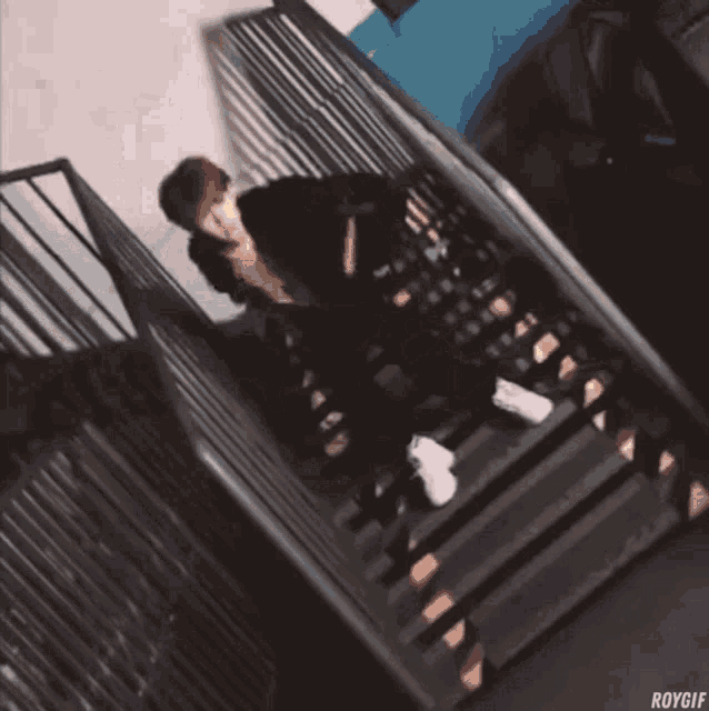 a person sitting on a set of stairs with roygif on the bottom