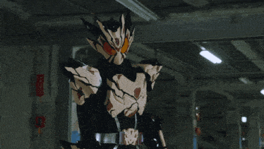 a man in a black and brown costume stands in a dark room with a fire extinguisher in the background