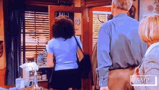 a man and a woman are standing in a room with a sign that says smp on it