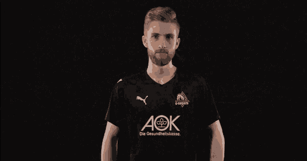 a man wearing a black shirt that says aok on the front