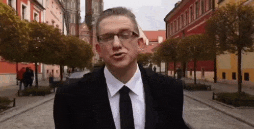 a man in a suit and tie is standing on a street