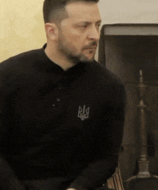 a man wearing a black shirt with the letter r on the front