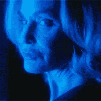 a woman 's face is lit up with blue light