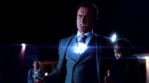 a man in a suit and tie stands next to a woman with a flashlight in her hand