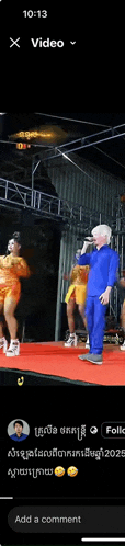 a man in a blue suit is singing into a microphone on a stage ..