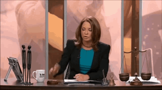 a woman sitting at a desk with a mug that says dr. jem