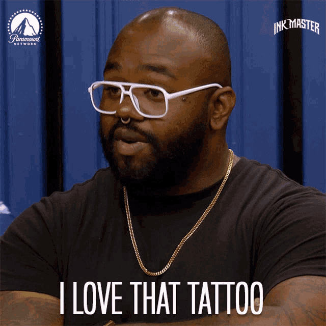 a man wearing glasses and a black shirt says " i love that tattoo "