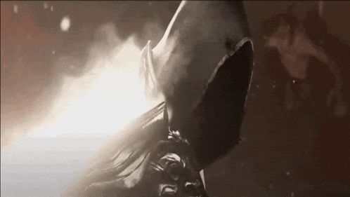a hooded figure is standing in the dark with smoke coming out of it .