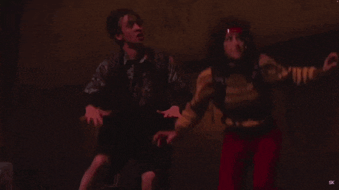 a man and a woman are standing next to each other in the dark .