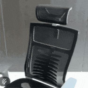 a black mesh office chair with a headrest is sitting on a desk