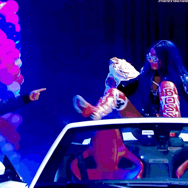 a woman sitting in a car with the word coca cola written on her boots