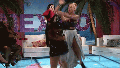 two women are dancing in front of a sign that says " exo "