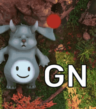 a stuffed animal with horns and a smiley face says gn in the grass