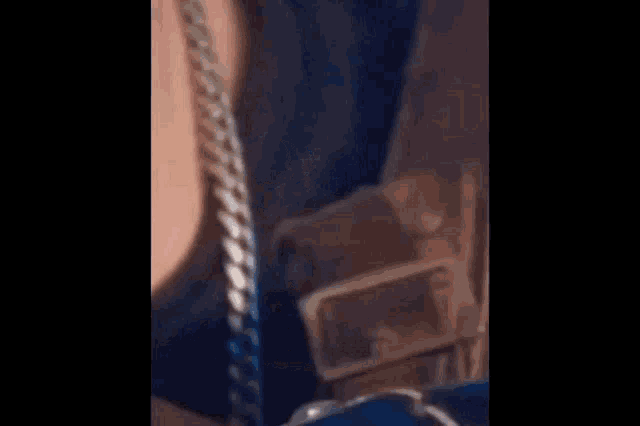 a person wearing a silver chain around their neck .