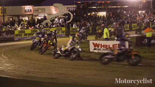 a group of motorcycle racers are racing in front of a sign that says whalen