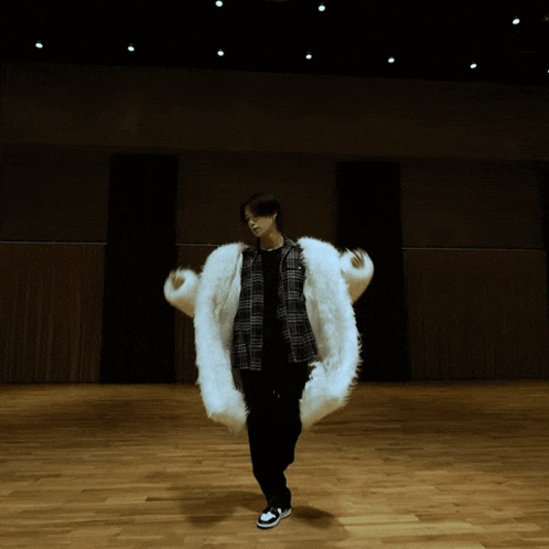 a person is holding a white fur coat in their hands