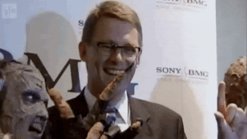a man in a suit and tie is smiling in front of a sign that says sony bmc