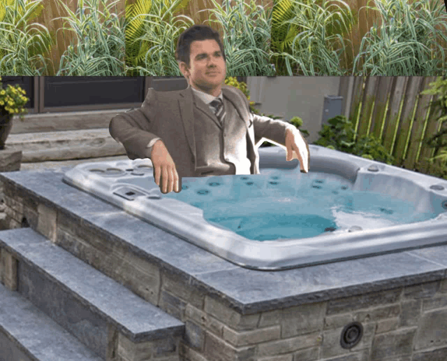 a man in a suit sits in a jacuzzi