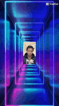 a picture of a man in a hoodie is surrounded by neon lights .