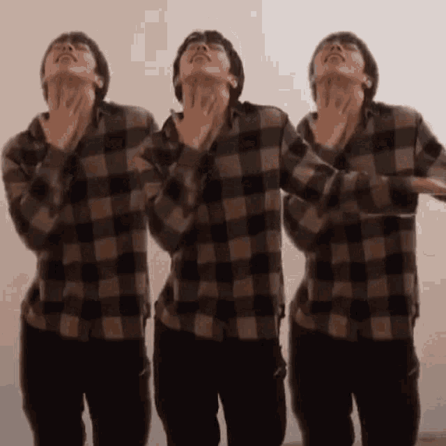three men in plaid shirts are dancing together .
