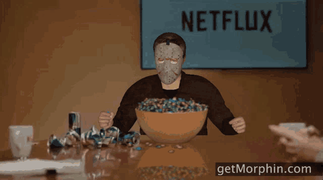 a man in a jason voorhees mask is holding a bowl of candy in front of a netflix logo