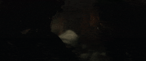 a man and a woman are looking at each other in the dark .