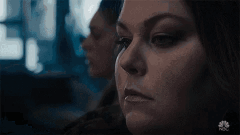 a close up of a woman 's face with a reflection of herself in a mirror .