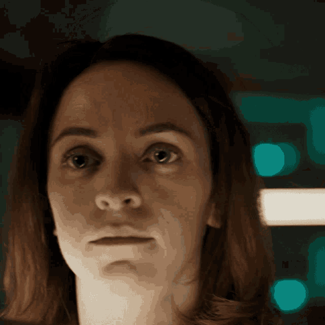 a close up of a woman 's face with a serious expression