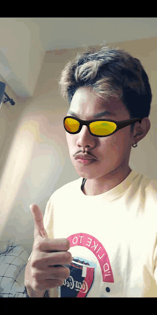 a man wearing sunglasses and a shirt that says " i like it " giving a thumbs up