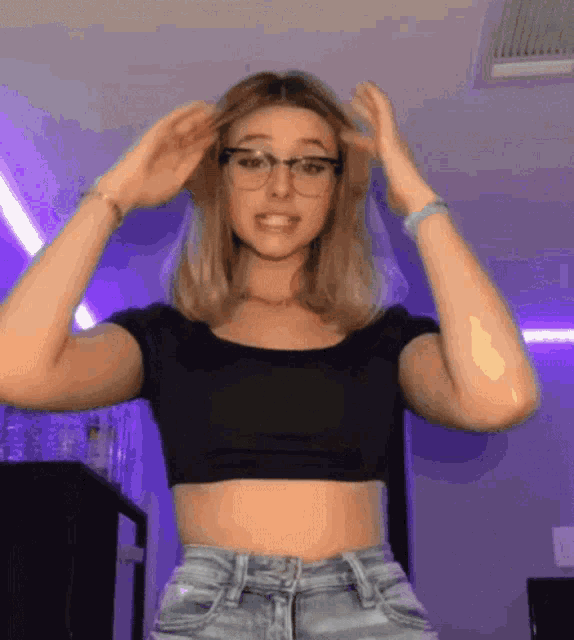 a woman wearing glasses and a crop top