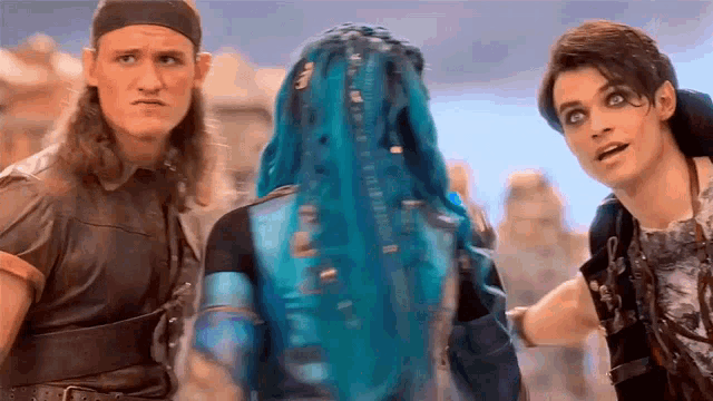 a group of people are standing next to each other and one has blue hair .