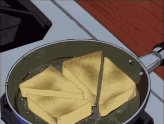 slices of cheese are cooking in a pan on a stove