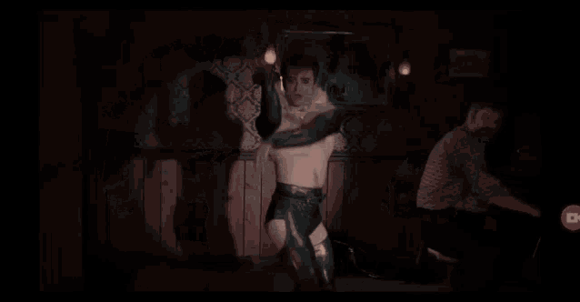 a man is without a shirt and is wearing a feathered collar and gloves .