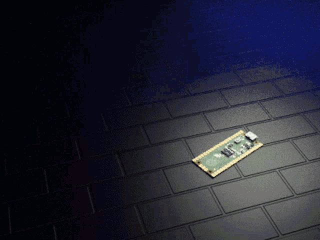 a small electronic device is laying on a black tiled floor