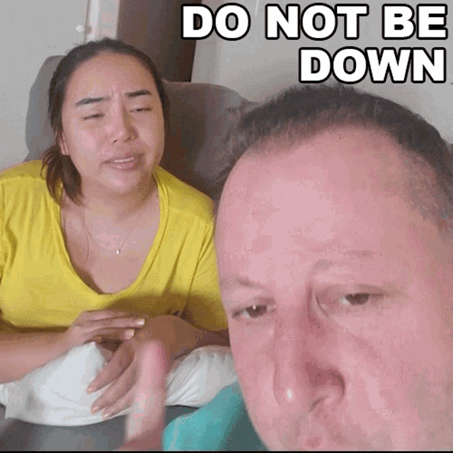 a man and a woman sitting next to each other with the words do not be down written above them