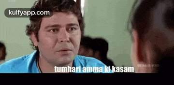 a man in a blue shirt is talking to a woman in a room and says tumhari amma ki kasam .