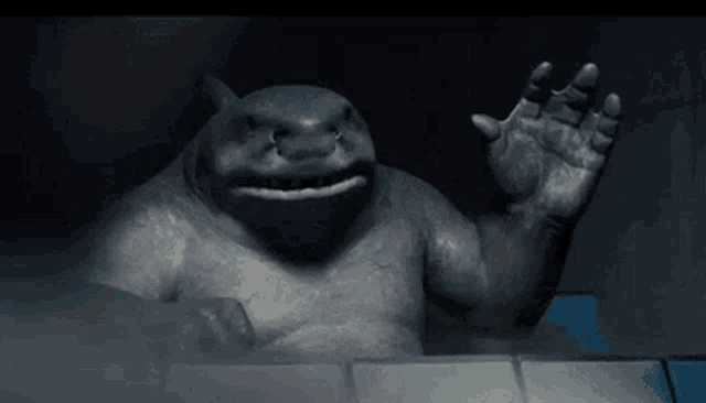 a statue of a shark is waving its hand in the dark