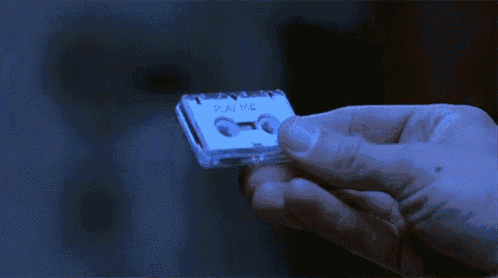 a person is holding a small cassette tape that says play me
