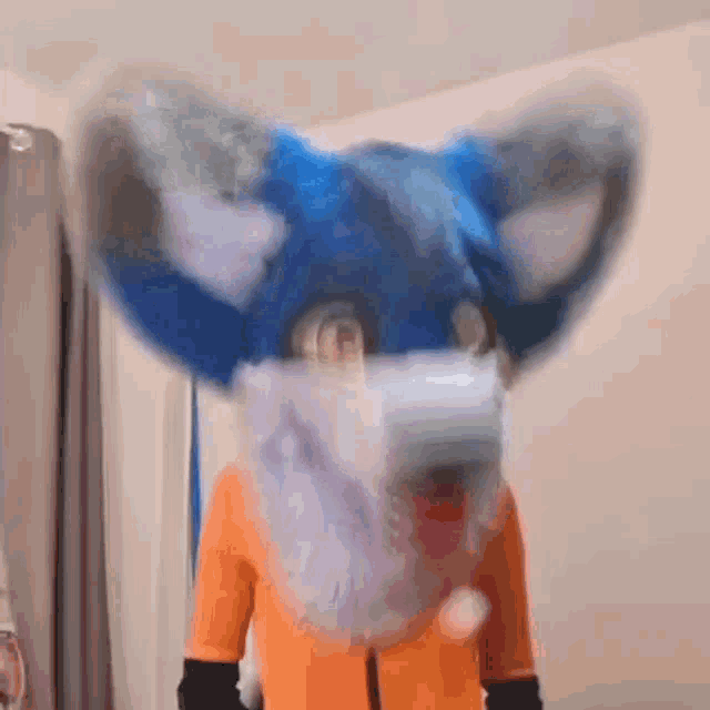 a person in a blue furry fox costume is wearing a face mask .